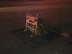 Дорожную яму в центре Ростова прикрыли новогодней елкой и установили предупреждающий знак